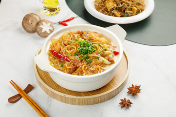 Delicious traditional Asian vermicelli noodle stew with mushrooms and herbs in ceramic bowl