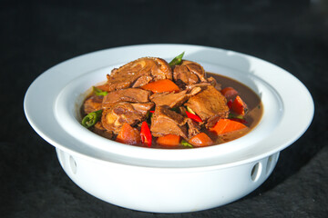 Slow Roasted Red Goose with Potatoes and Vegetables in Traditional White Serving Dish