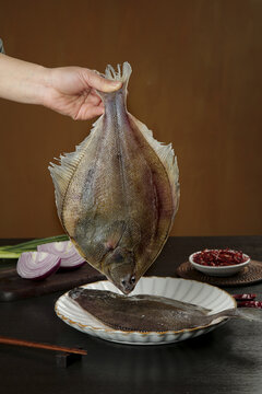 Fresh Whole Flounder Fish Being Prepared for Cooking in Kitchen with Ingredients