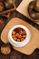 Han Luo Guo Traditional Chinese Herbal Tea with Roasted Fruit Slices on Rustic Wooden Background