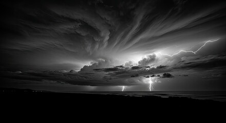 Dramatic black and white storm clouds with lightning striking over the ocean.