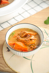 Roasted Duck Soup with Carrots in Rustic Kitchen Setting - Homemade Comfort Food Meal