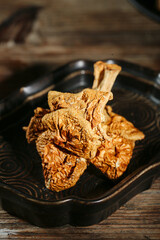 Yunnan Dried Specialty Mushrooms in Black Bowl on Wooden Table - Asian Cooking Ingredients