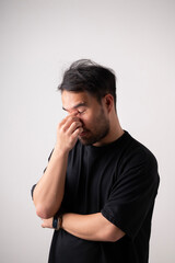 A man is worried alone. A worried young man holds his forehead. A tired man holds his head.
