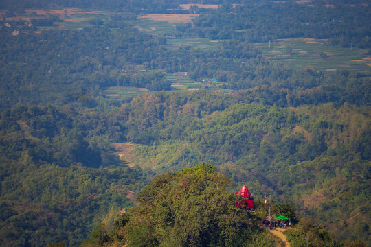 Red Hilltop Temple Overlooking Lush Green Forest and Distant Valley