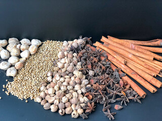 An arrangement of Indonesian spices that are a delicious and distinctive cooking spice, cooking spices arranged on a black base