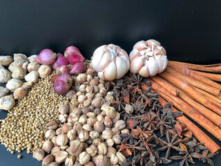 An arrangement of Indonesian spices that are a delicious and distinctive cooking spice, cooking spices arranged on a black base