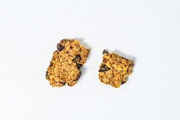 Delicious two granola bars with almonds, oats, and dried cranberries, isolated on a white background. Top view, high angle, above, Close up. clipping path. piece. Flat lay. broken. cracked.