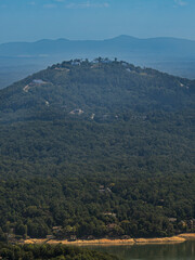 Fototapeta premium Scenic view of mountain ridges covered with dense forest and scattered houses on the slopes