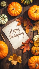 A seasonal scene featuring small pumpkins, gourds, leaves, and paper with "Happy thanksgiving" script on dark wood table