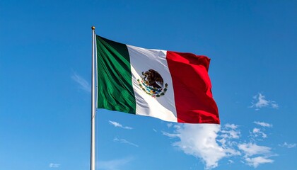 “Mexican flag waving against a clear blue sky. Features green, white, and red vertical stripes with central coat of arms—an eagle perched on a cactus holding a snake. Clean, dynamic composition with n