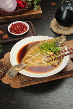 Steamed Whole Fish with Soy Sauce and Scallions Traditional Asian Seafood Dish on Wooden Table