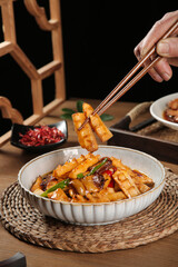 Stir-fried bamboo shoots with smoked bacon and pork in Asian cuisine bowl with chopsticks