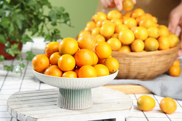 Fresh Kumquats and Longan Fruits in White Bowls on Wooden Table - Healthy Organic Citrus Display