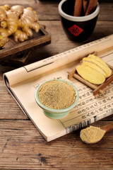 Traditional Chinese Medicine Ginger Powder and Herbs on Ancient Scroll with Calligraphy