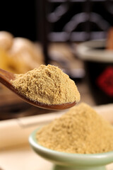 Ginger Powder Spice on Wooden Spoon with Assorted Ground Spices in Kitchen Background