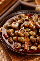 Spicy Stir-Fried Whelk Seafood in Clay Bowl - Traditional Asian Marine Cuisine Dish