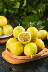Golden Passion Fruits in Bamboo Basket on Dark Wood Base with Tropical Green Background