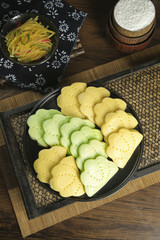 Traditional Korean Two-Color Handmade Rice Cookies with Ruffled Edges on Black Plate