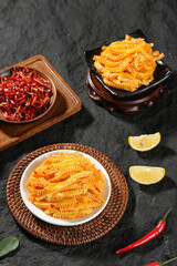 Spicy Konjac Tripe Strips with Chili Peppers - Traditional Asian Vegetarian Food on Dark Slate Background