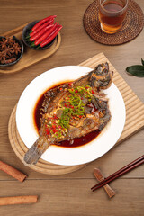 Braised Plaice Fish with Soy Sauce - Traditional Asian Seafood Dish on Wooden Table