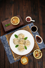 Xiamen Bamboo Shoot Dumplings with Sauces - Traditional Chinese Gourmet Snacks on Wooden Table