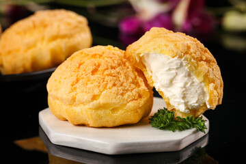 Golden Cream Puffs with White Filling on Marble Plate - Crispy Pastry Dessert