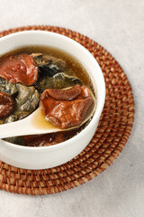 Chicken and Porcini Mushroom Soup in White Bowl on Bamboo Placemat - Traditional Asian Cuisine