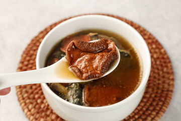 Porcini Mushroom and Chicken Soup in White Bowl with Wooden Spoon