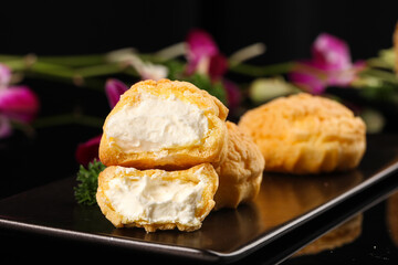 Cream Puff Pastry Balls with Custard Filling on Elegant Black Plate