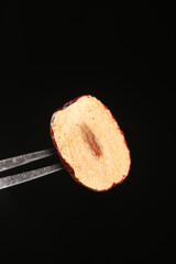 Hotan Xinjiang Red Jujube Date Cut in Half Showing Sweet Flesh and Pit on Black Background