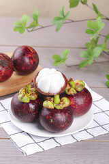 Fresh Thai Mangosteen Tropical Fruit with White Flesh on Rustic Wood Background