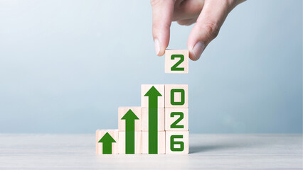 Wood block cubic stacking step up with Green Arrow Blue Tone. Business growth success process. Business Concept. Up Trend. 2026. Ratio  16:9