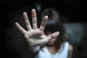 A young girl is expressing a strong sense of denial with her raised hand.