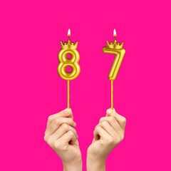 Hands holding number shaped candles - Birthday number 87