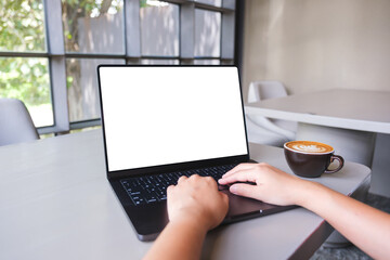 Mockup image of a woman working and typing on laptop computer with blank white desktop screen in cafe