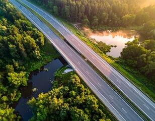 Highway crossing a forest and a pond at sunrise