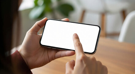 Close up of person holding a smartphone horizontally with finger touching blank screen for website or app interface mockup