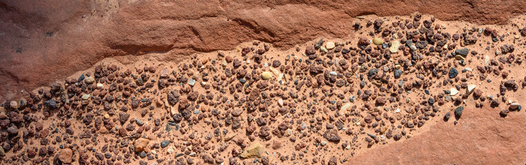 Closeup of orange red sandstone rock with a dip full of sand and pebbles, as a nature background, Zion National Park, Utah
