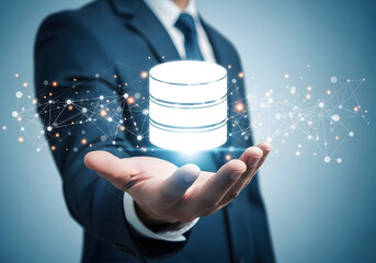 Businessman holding a glowing database icon with digital connections, representing data management and technology