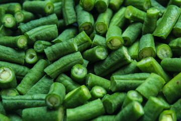 The texture of fresh green long bean pieces piled together. These vegetable pieces are ready to be cooked as a healthy ingredient, traditional food, or vegetarian dish.