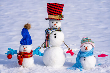 Funny snowman in winter background. Snowman in winter holiday. Decorated snowman. Greeting card for New Year and Christmas poster. Family snowmen with snow background. Xmas winter banner.