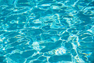 Blue pool water background. Blurred transparent clear calm water surface texture. Water waves in sunlight with copy space.