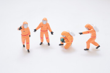 Miniature Orange Astronaut Figures Exploring Space Scene