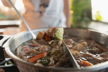 Delicious and Flavorful Asian Hot Pot with Fresh Vegetables, Tender Meat, and Aromatic Broth Served in a Modern Restaurant Setting