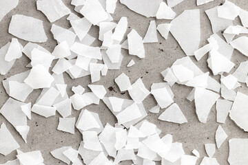 Close-Up of Magnesium Salt Flakes on grey concrete background, detailed white particles sea salt,...