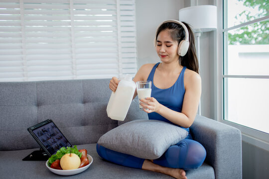 A joyful child and woman indoors holding glasses of milk, smiling happily, symbolizing health, freshness, nourishment, and a positive lifestyle.
