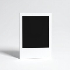 Single, blank instant photograph stands upright against a white background, its surface casting a subtle shadow. Minimalist aesthetic
