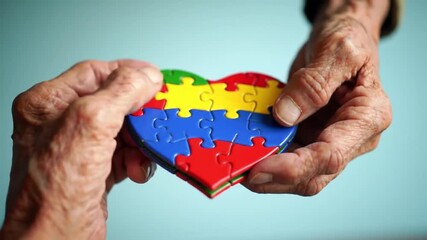 Elderly hands holding a heart-shaped puzzle, symbolizing autism awareness and support. - Powered by Adobe