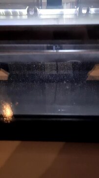 An experiment at the Hadron Collider. White particles are visible against a dark background, raining down chaotically. Electrical discharges or flashes periodically appear and disappear between them